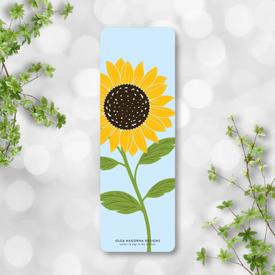 Bookmark with a sunflower design on a light blue background, surrounded by green leaves.