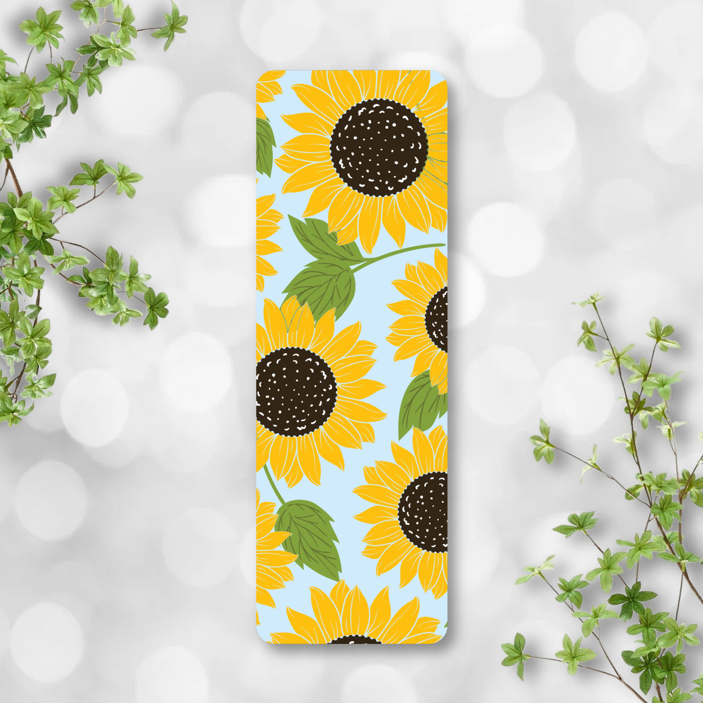 Bookmark sunflower pattern on a light gray background with green leaves.