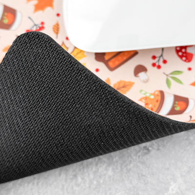 Close-up of a black textured corner on a surface with a patterned mat underneath.
