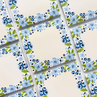 Sticky memo pads with blue floral pattern on a beige background.