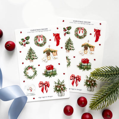 Two sheets of Christmas-themed decorative stickers with wreaths, trees, and ribbons on a white background.