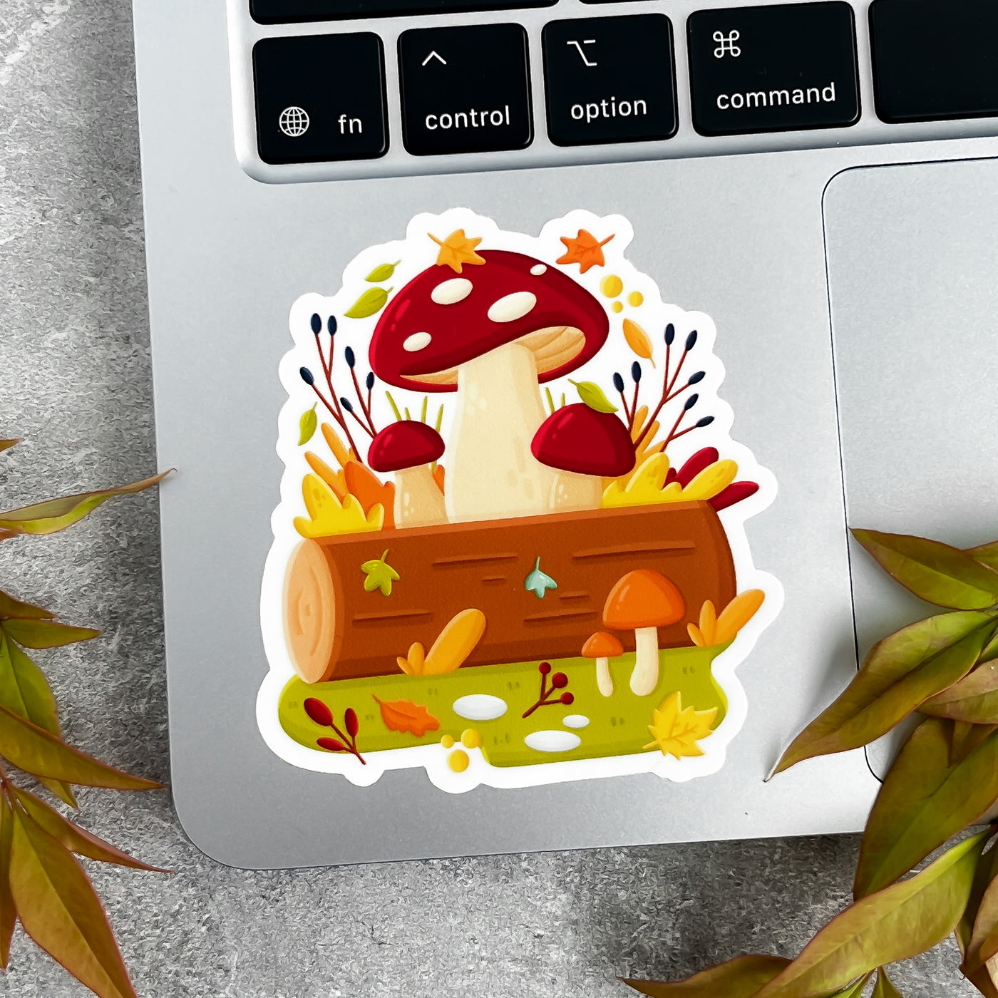 Sticker with mushrooms and leaves on a laptop keyboard.