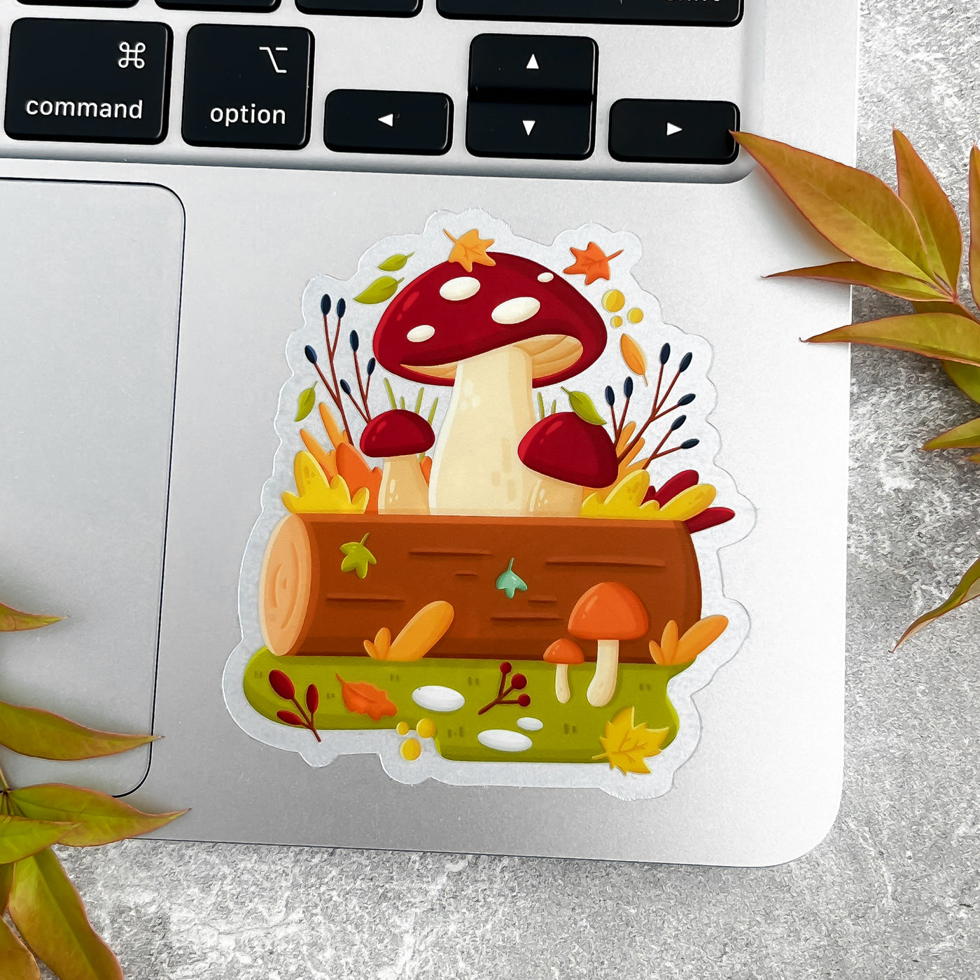 Sticker with mushrooms and a log on a laptop.
