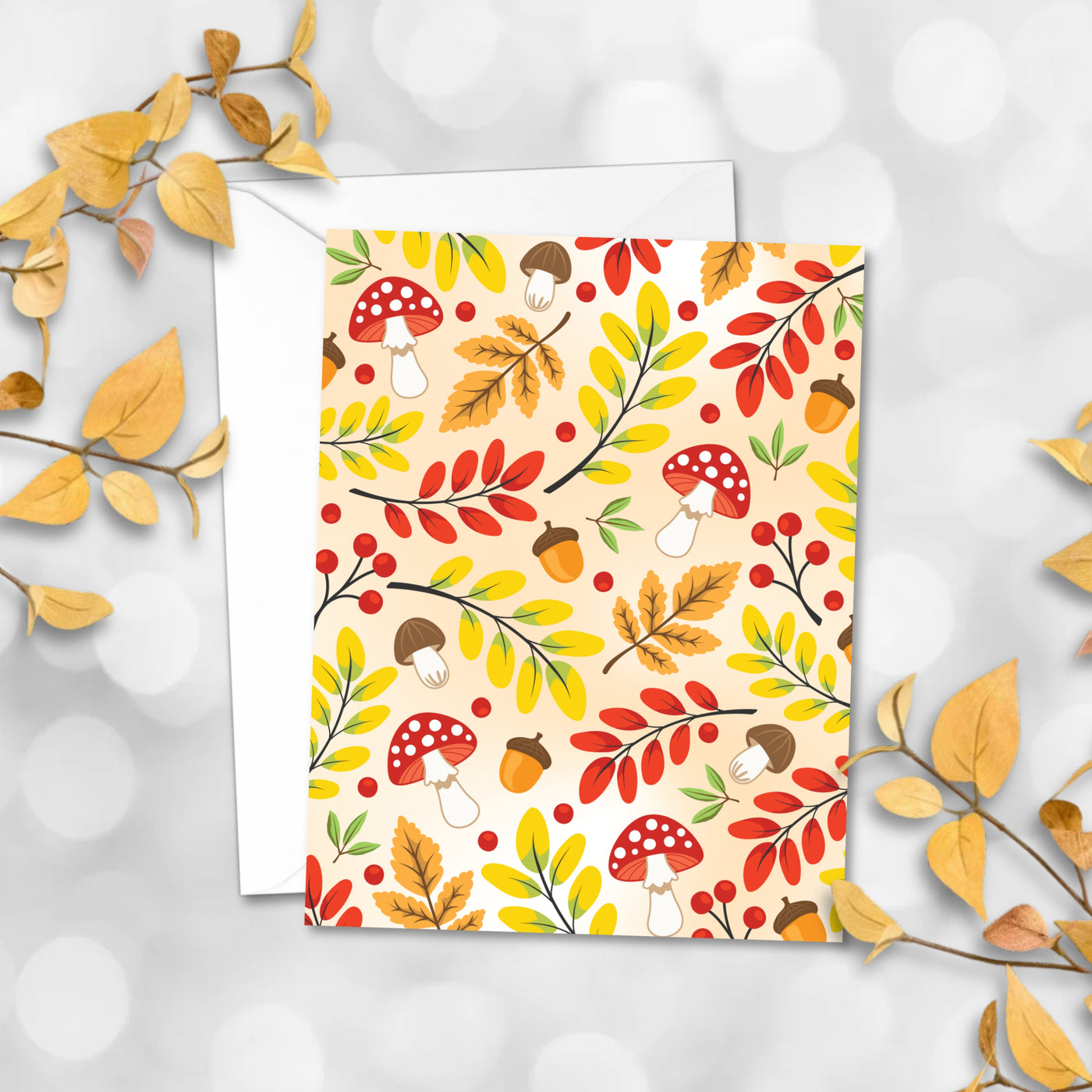 Greeting card with autumn design featuring leaves, mushrooms, and acorns on a white background.