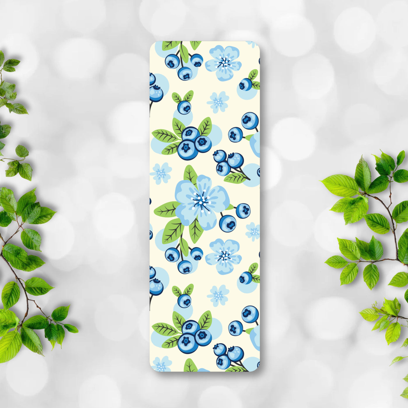 Bookmark with blue floral and berry pattern on a light background.