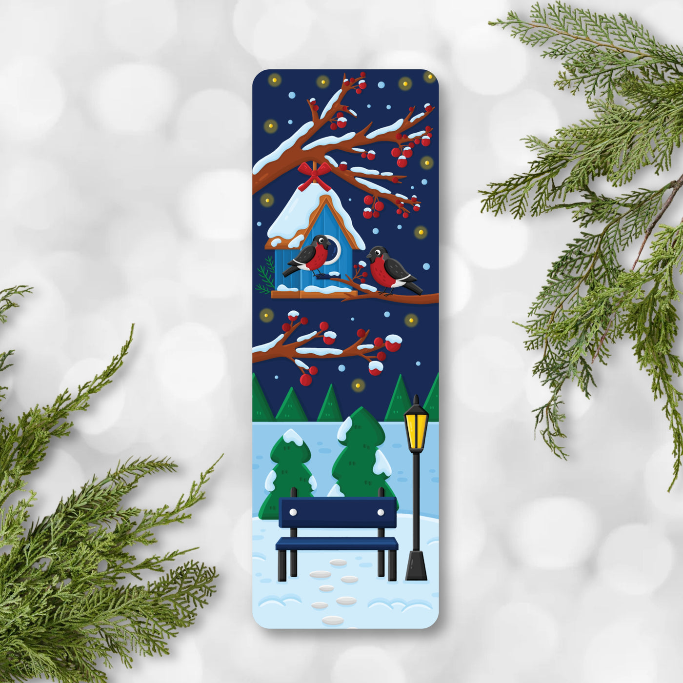 Winter-themed bookmark with snowy scene, birds, and bench on a white background with greenery.